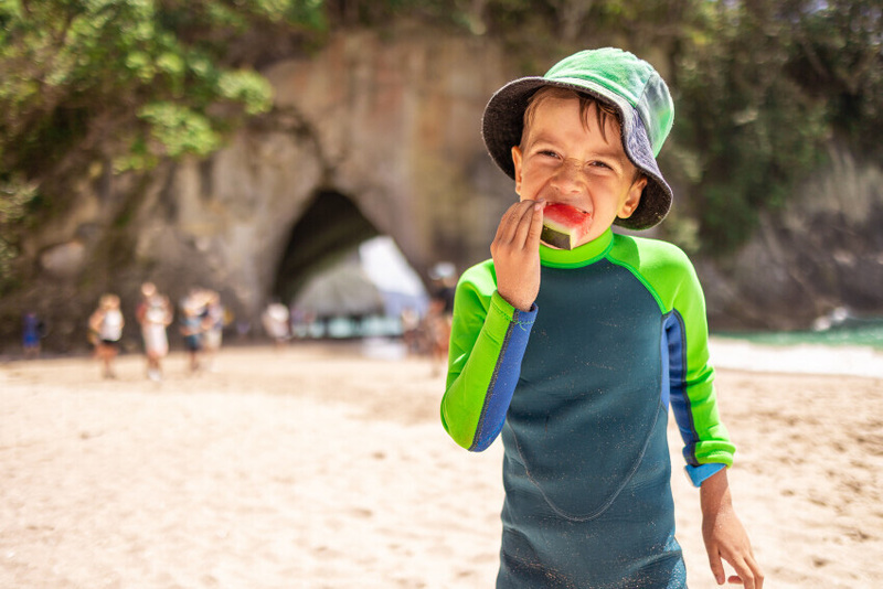Child on beach eating watermelon
